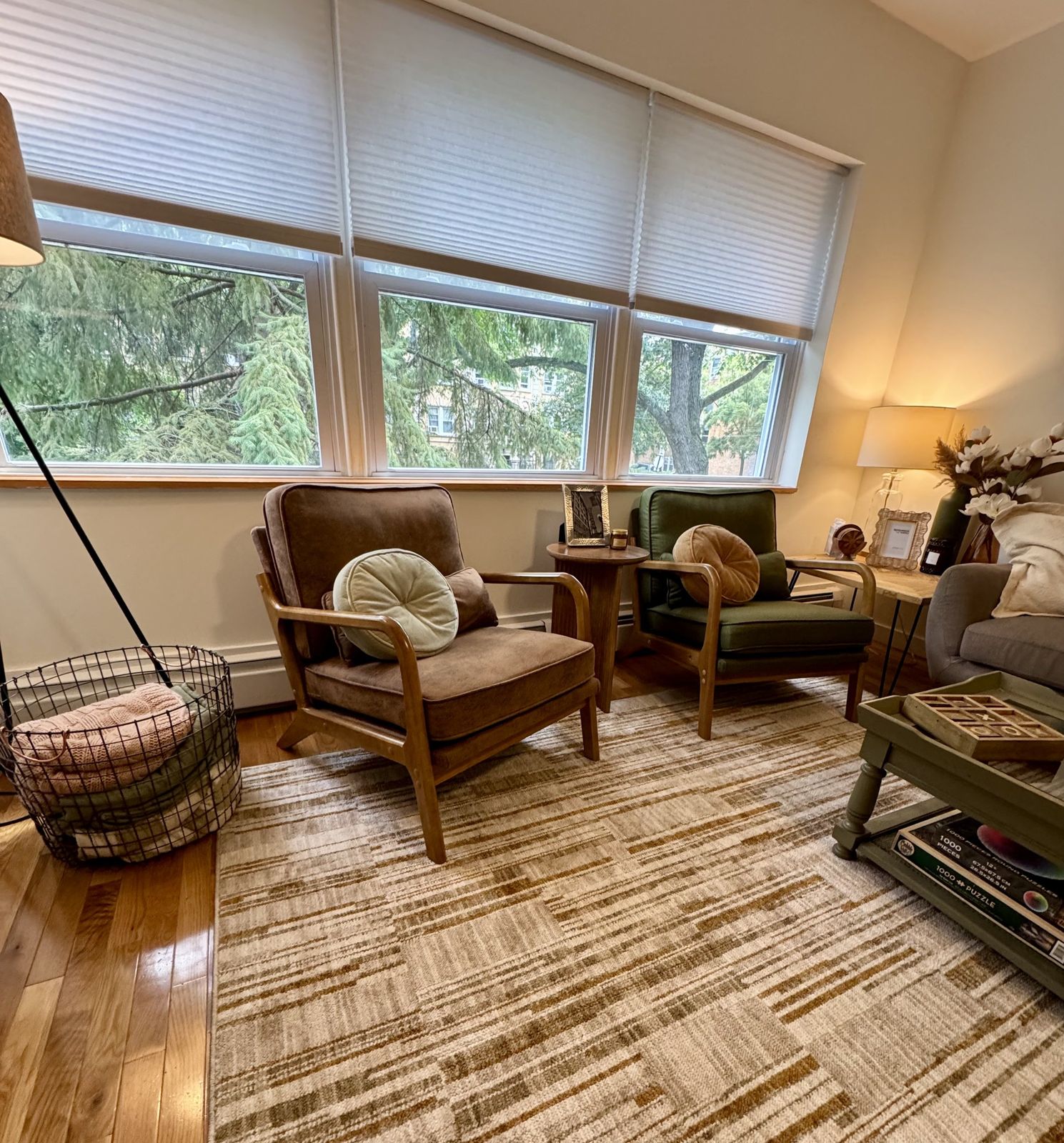 Two armchairs under a row of windows looking onto trees